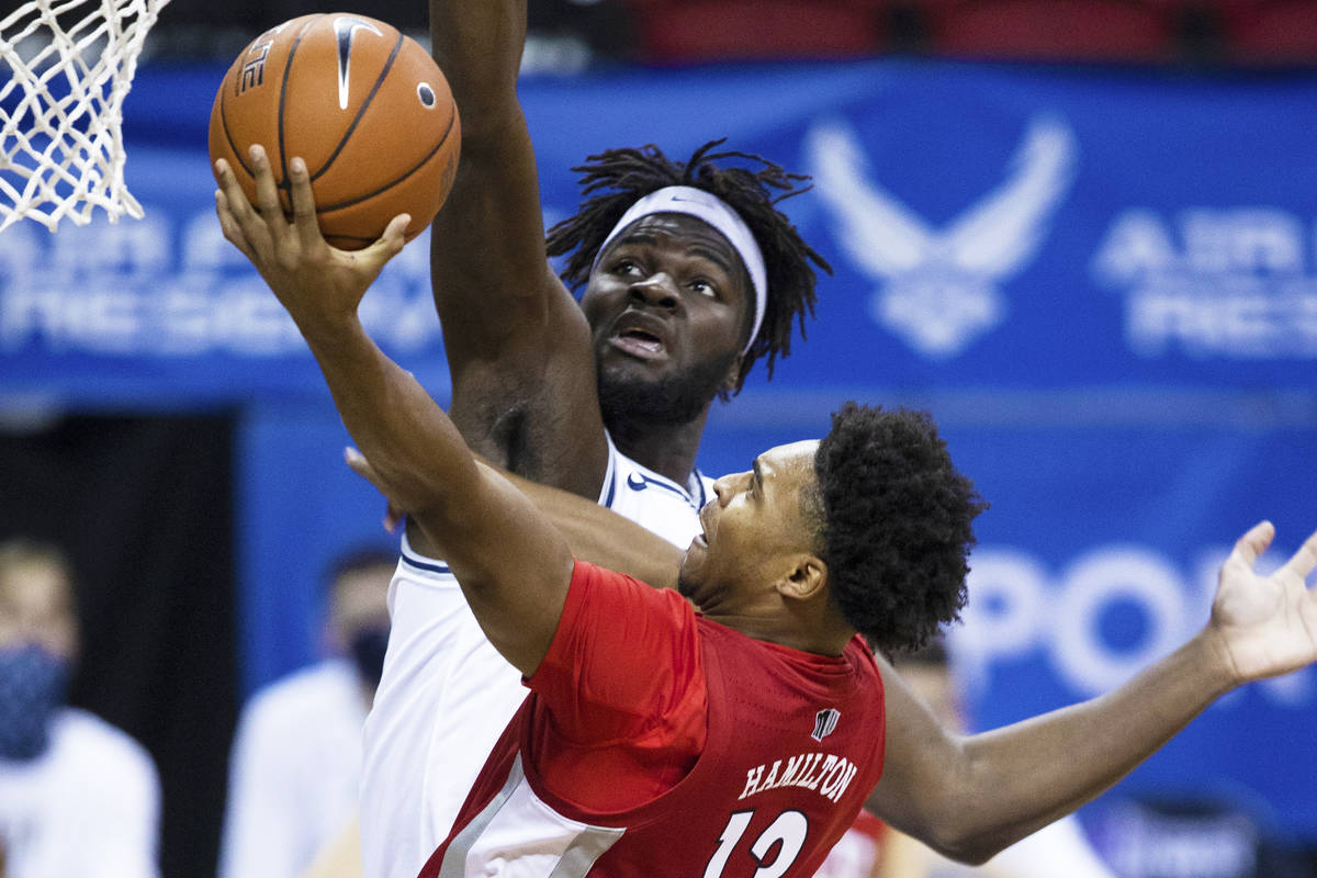 UNLV Rebels guard Bryce Hamilton (13) drives past Utah State Aggies center Neemias Queta (23) i ...