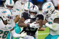 Raiders wide receiver Nelson Agholor (15) is stacked up by Miami Dolphins strong safety Bobby M ...