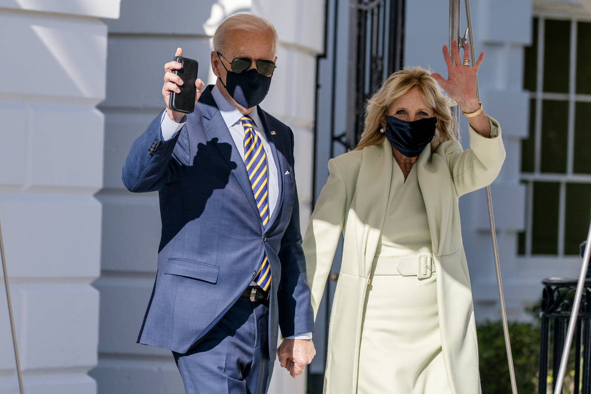 President Joe Biden, accompanied by first lady Jill Biden, waves as he walks to Marine One upon ...