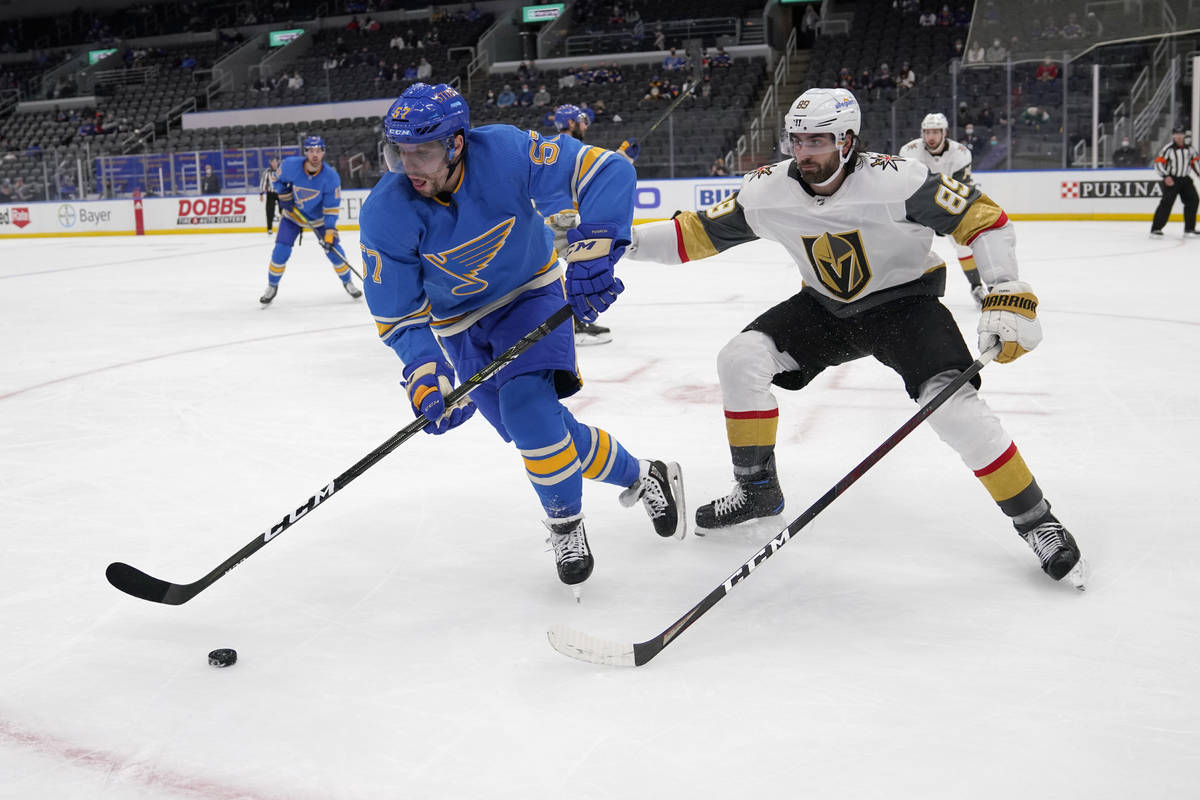 St. Louis Blues' David Perron (57) and Vegas Golden Knights' Alex Tuch (89) chase after a loose ...