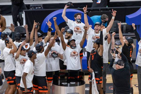 Oregon State Beavers head coach Wayne Tinkle and players celebrate their win with a trophy afte ...