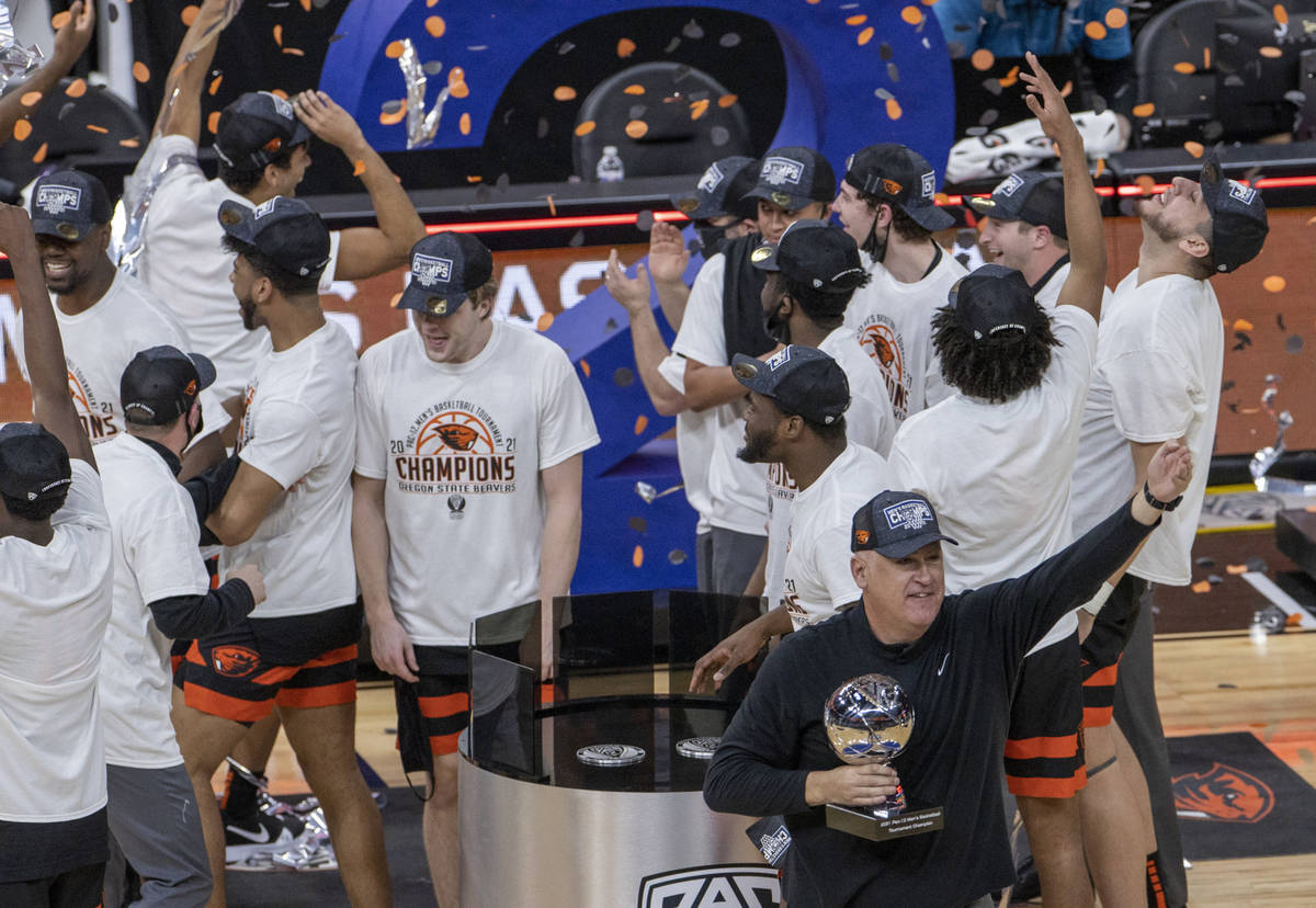 Oregon State Beavers head coach Wayne Tinkle and players celebrate their win with a trophy afte ...