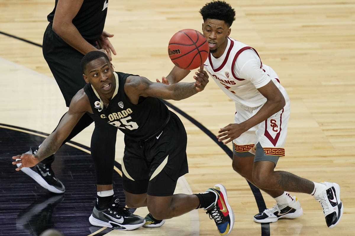 Colorado's McKinley Wright IV, left, and Southern California's Tahj Eaddy (2) vie for the ball ...