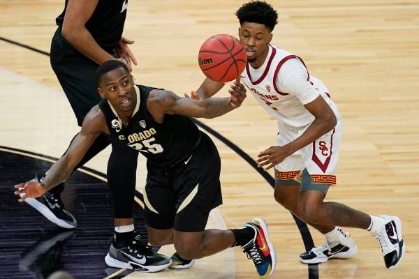 Colorado's McKinley Wright IV, left, and Southern California's Tahj Eaddy (2) vie for the ball ...