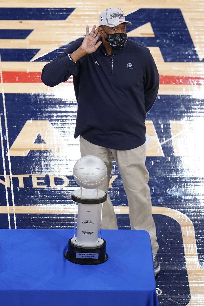Georgetown head coach Patrick Ewing gestures towards fans while standing next to the tournament ...