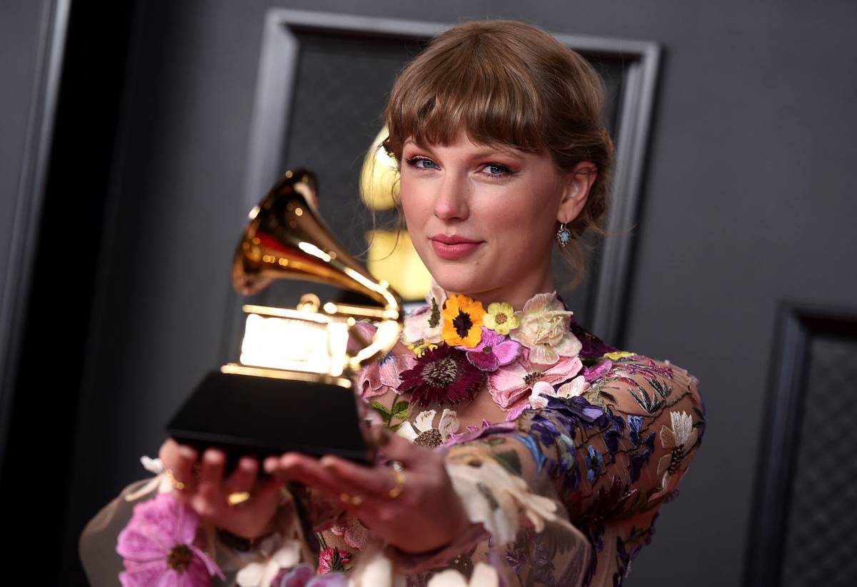 Taylor Swift poses in the press room with the award for album of the year for "Folklore" at the ...