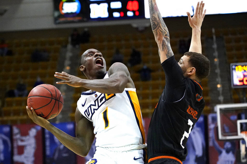 UNC-Greensboro guard Isaiah Miller (1) drives the ball to the basket around Mercer guard Neftal ...