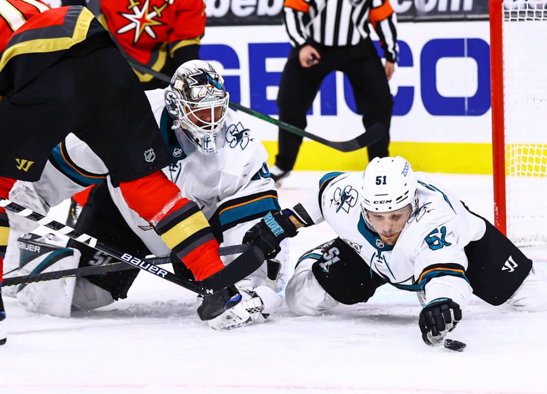 San Jose Sharks' Radim Simek (51) reaches for the puck alongside goaltender Devan Dubnyk (40) d ...