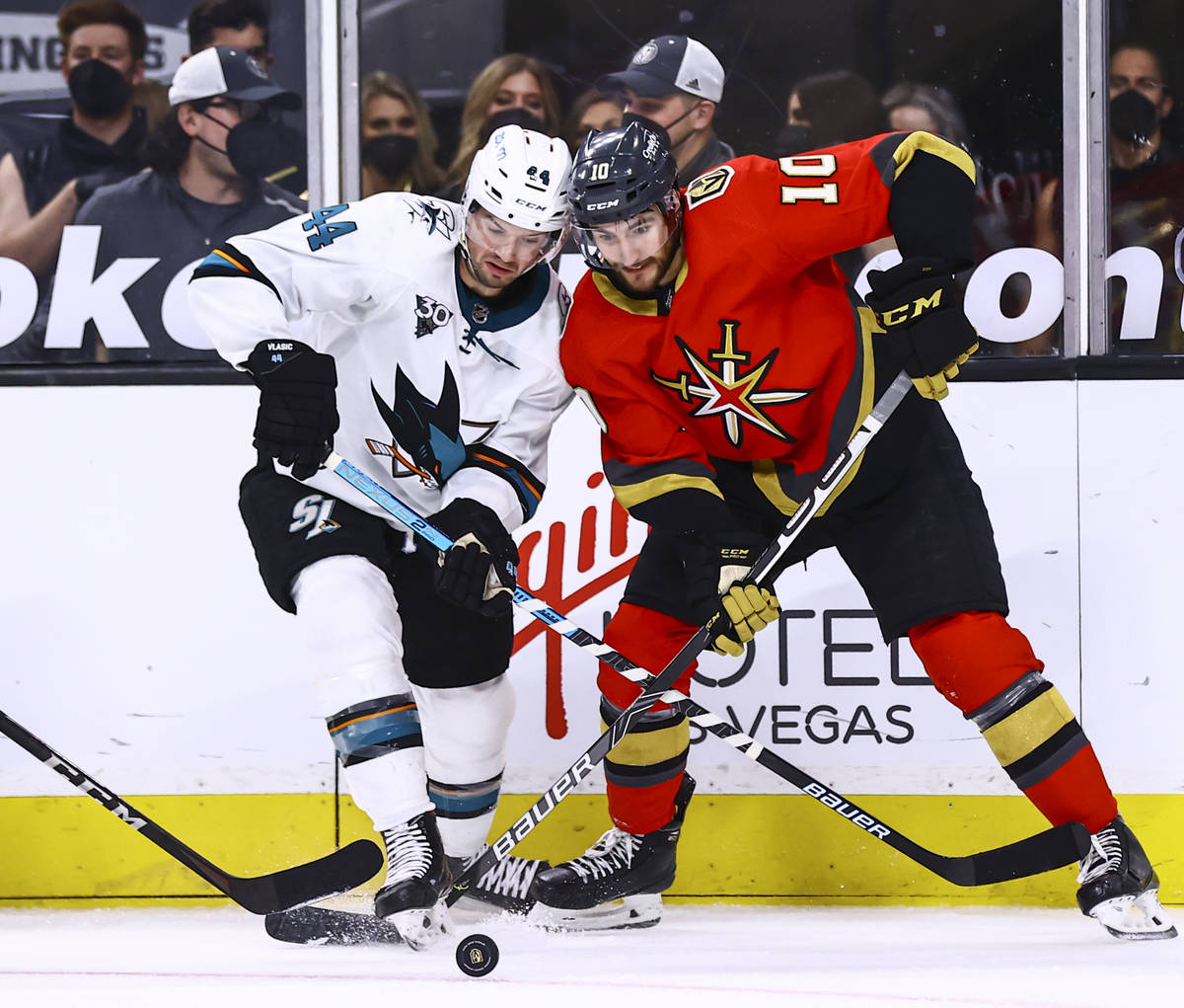 San Jose Sharks' Marc-Edouard Vlasic (44) and Golden Knights' Nicolas Roy (10) battle for the p ...