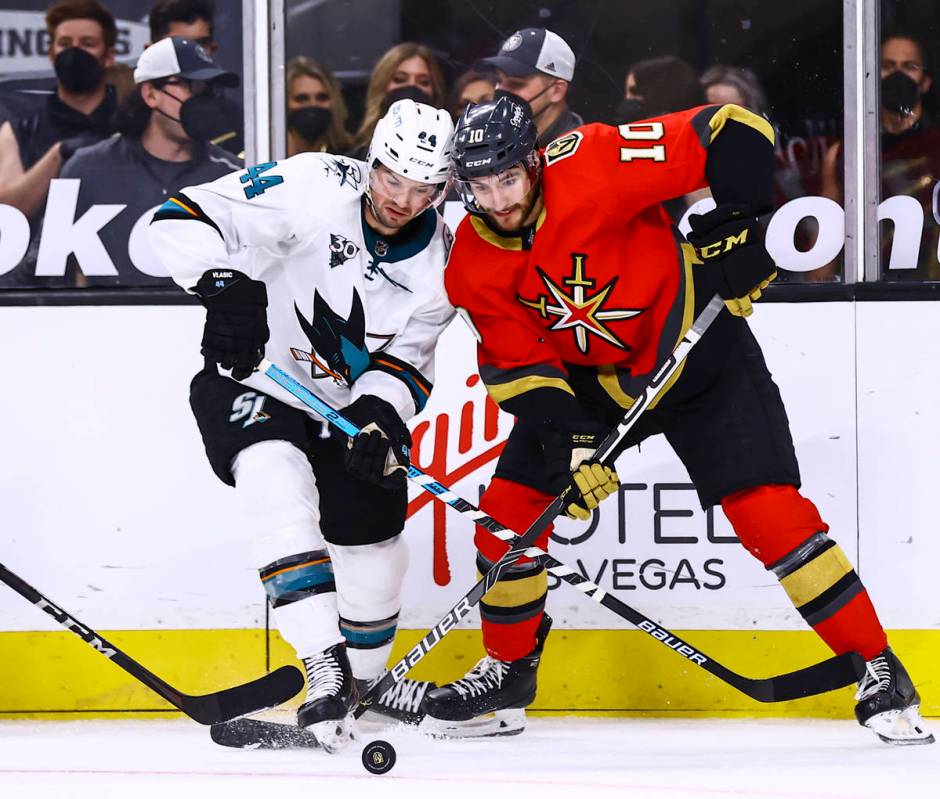 San Jose Sharks' Marc-Edouard Vlasic (44) and Golden Knights' Nicolas Roy (10) battle for the p ...