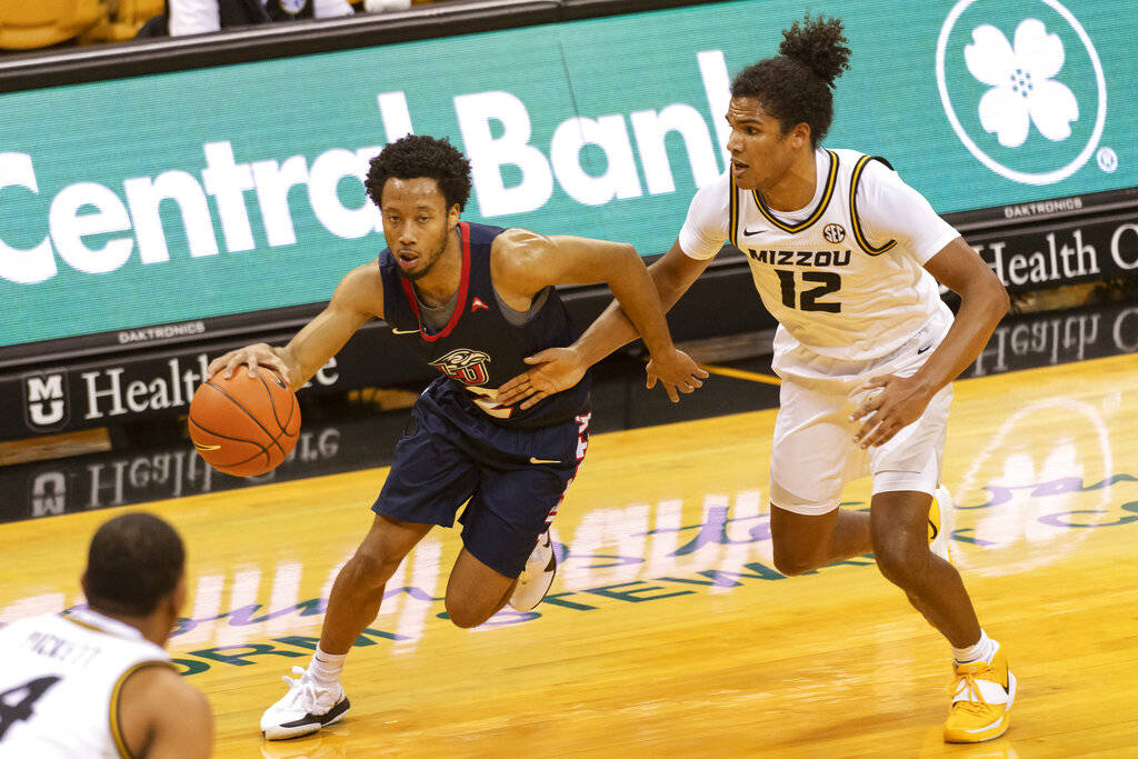 Liberty's Darius McGhee, left, drives past Missouri's Dru Smith, right, during the first half o ...