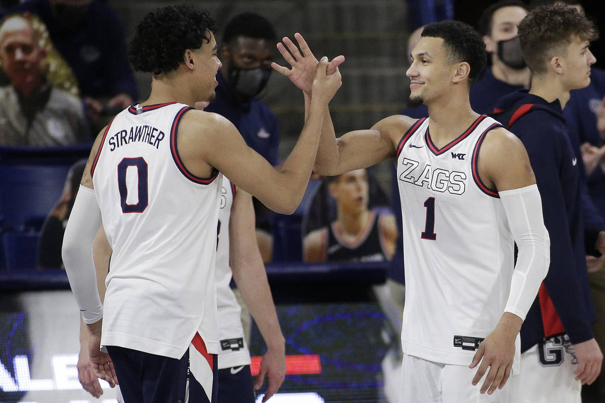 Gonzaga guard Julian Strawther (0) greets guard Jalen Suggs (1) during introductions before the ...