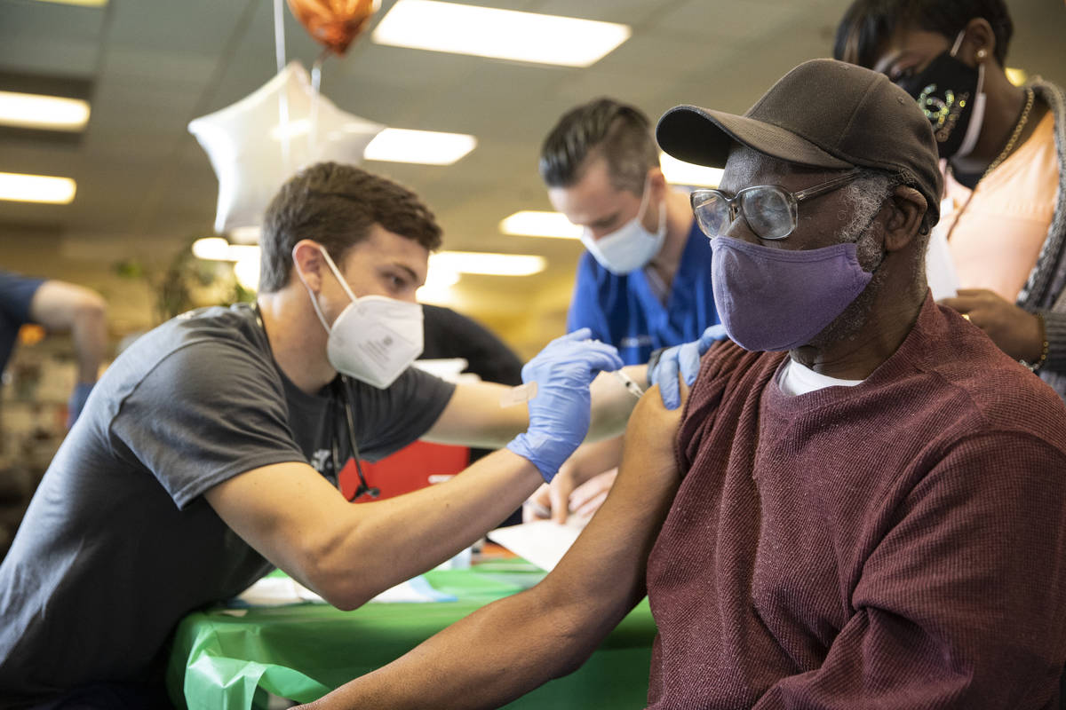 Otis Thrower, 76, right, receives the COVID-19 vaccine from Touro University Nevada physician a ...