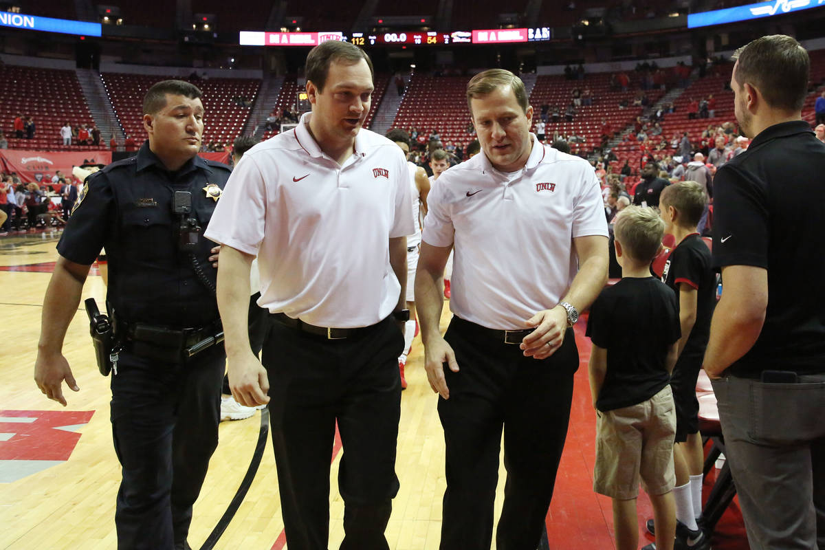 UNLV's basketball head coach T.J. Otzelberger, right, and assistant coach Kevin Kruger leave th ...