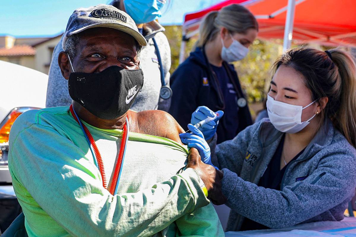 Debbie Min, right, a physician assistant student from Touro University, administers a COVID-19 ...