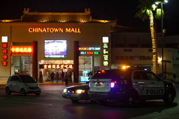 Metropolitan police are stationed in the Chinatown Plaza parking lot on Wednesday, March 17, 20 ...