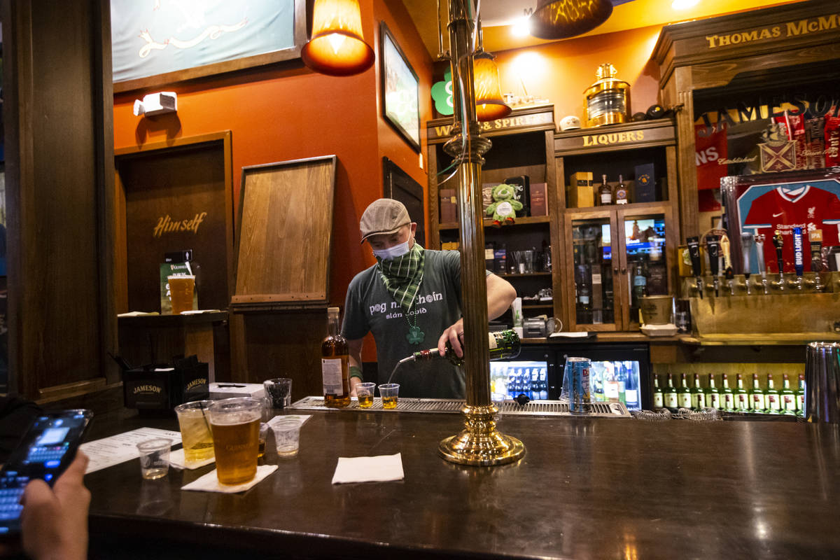 Bartender Paul Walsh Jr. prepares drinks as people gather to celebrate St. Patrick's Day at McM ...