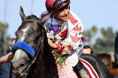 Jockey Mike Smith celebrates after riding Roadster to the win in the Santa Anita Derby horse ra ...