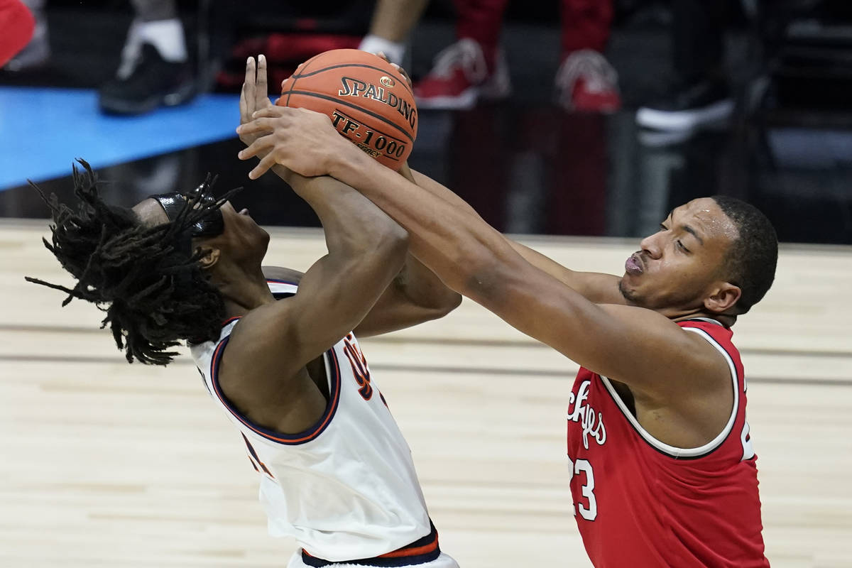 Illinois's Ayo Dosunmu (11) is tied up by Ohio State's Zed Key (23) during the first half of an ...