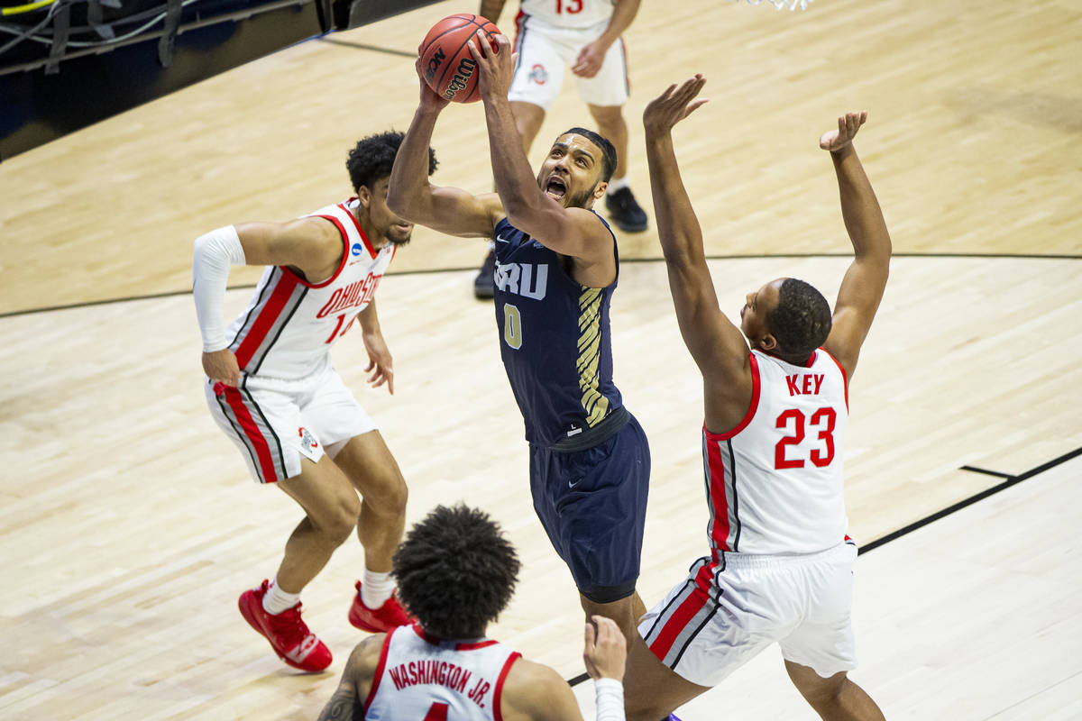 Oral Roberts' Kevin Obanor (0) goes up for a shot between Ohio State's Justice Sueing (14), Dua ...