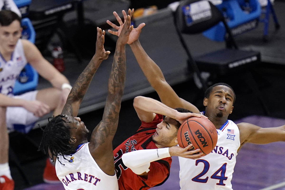 Eastern Washington guard Michael Meadows, center, gets pressure from Kansas guard Marcus Garret ...