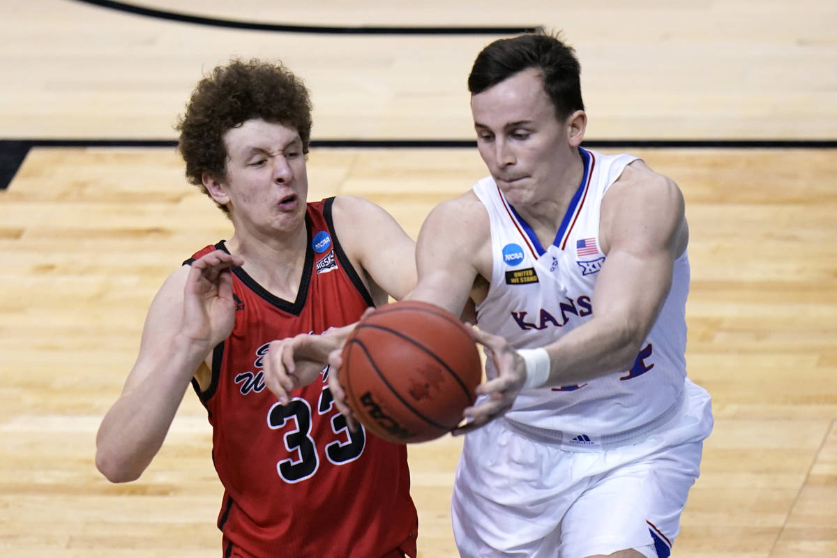 Kansas forward Mitch Lightfoot, left, and Eastern Washington guard Jacob Groves (33) chase a lo ...