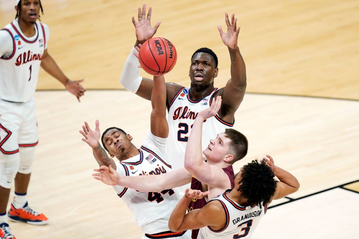 Loyola Chicago's Tate Hall, second from right, shoots against Illinois defenders Adam Miller, l ...