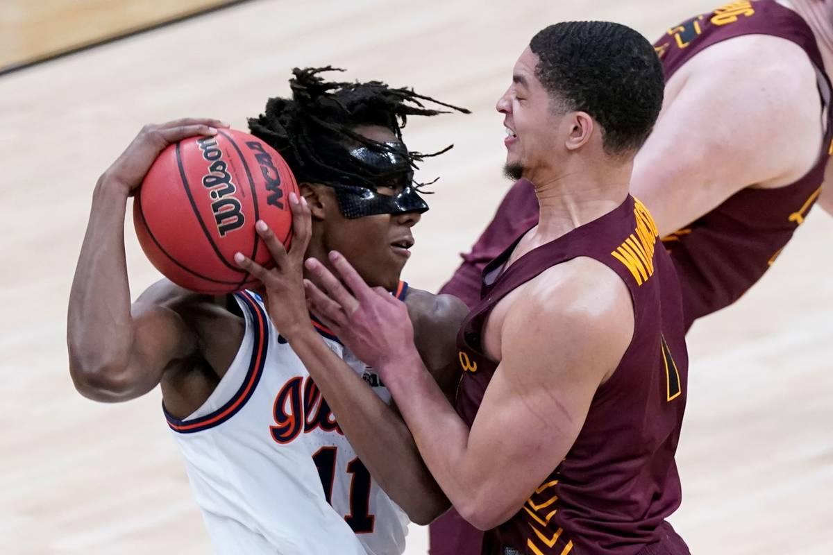 Loyola Chicago's Lucas Williamson (1) defends against Illinois' Ayo Dosunmu (11) during the fir ...