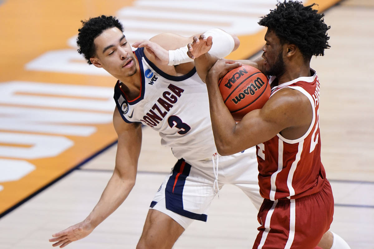 Gonzaga guard Andrew Nembhard (3) fights for a rebound with Oklahoma guard Elijah Harkless (24) ...