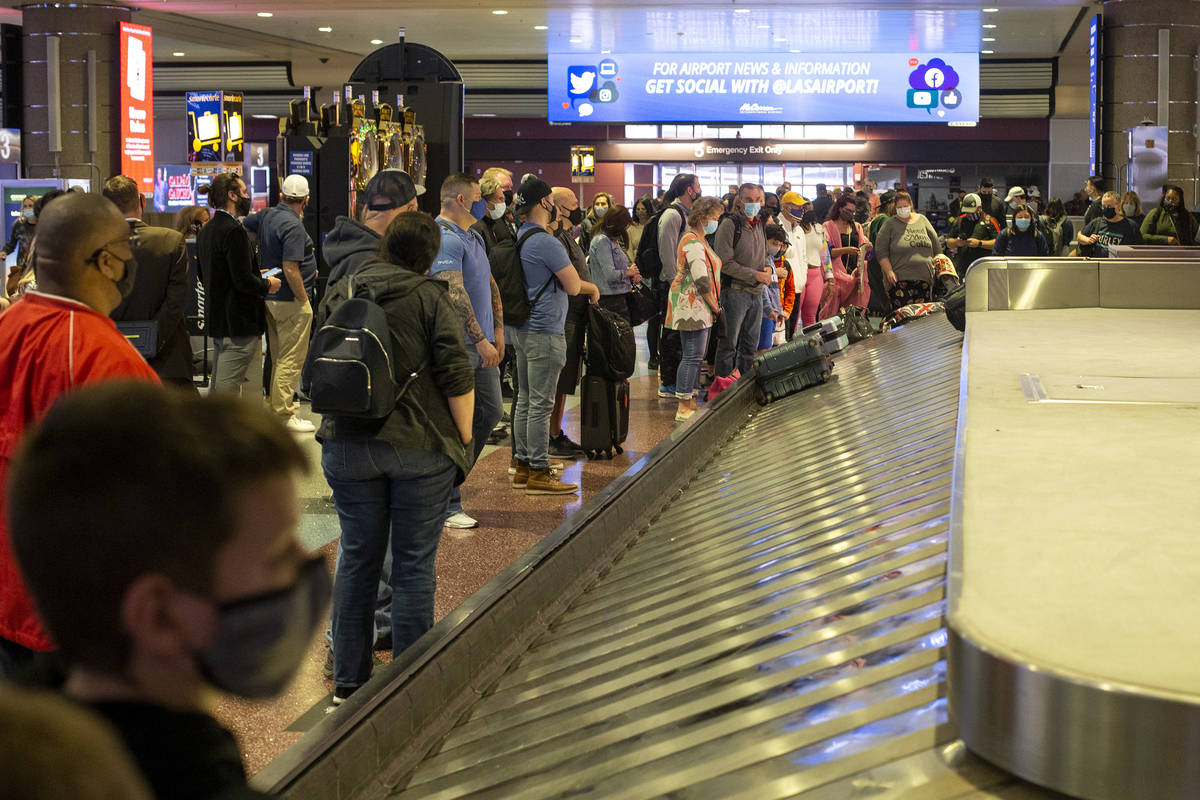 Visitors to Las Vegas, wearing personal protective equipment to prevent the spread of COVID-19, ...