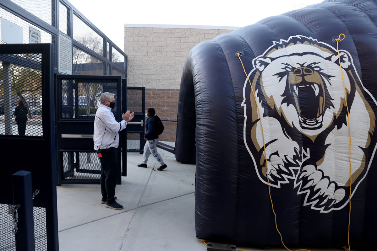 Principal Tam Larnerd welcomes students arriving through an inflatable tunnel on the first day ...