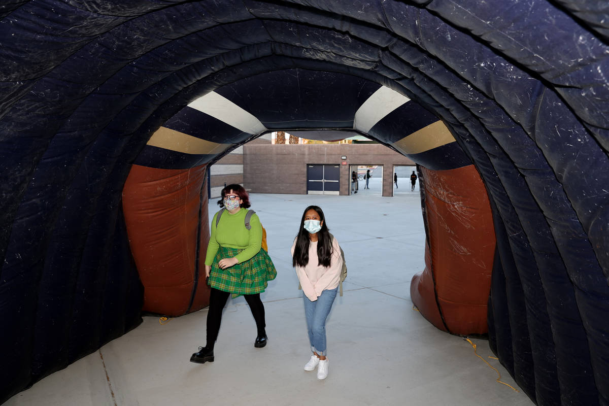 Students, including seniors Zoey Cornelius, left, and Noemi Torres enter through an inflatable ...