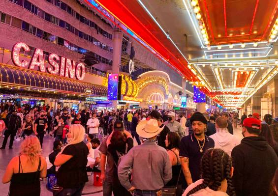 People walk along Fremont Street Experience in Las Vegas, Friday, March 19, 2021. (David Guzman ...