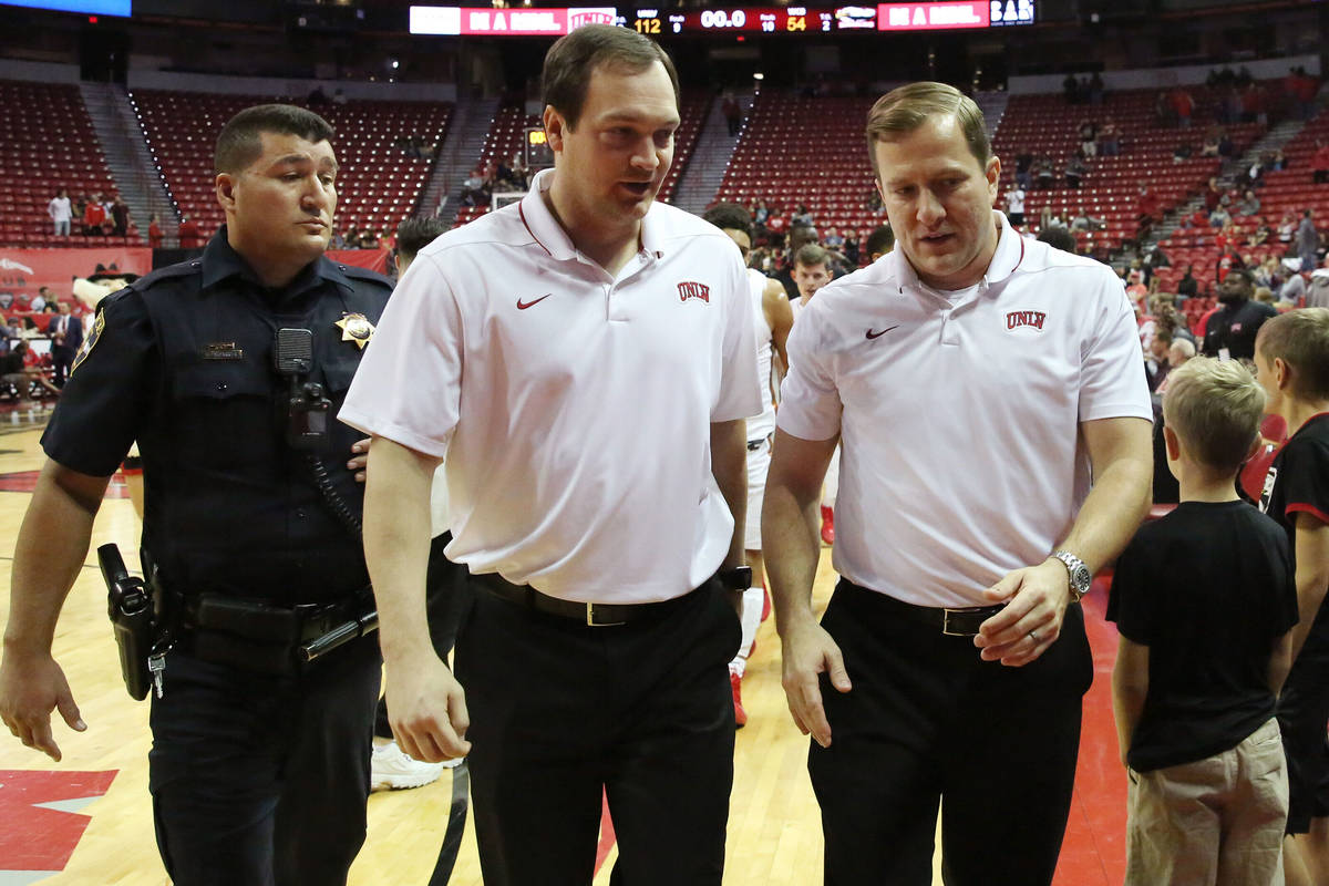 UNLV's basketball head coach T.J. Otzelberger, right, and assistant coach Kevin Kruger leave th ...