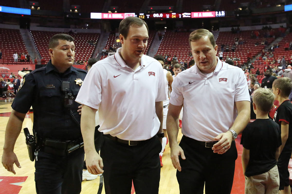 UNLV's basketball head coach T.J. Otzelberger, right, and assistant coach Kevin Kruger leave th ...