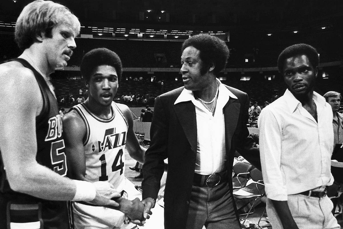 New Orleans Jazz Coach Elgin Baylor (in coat) shakes with, from left, Kent Benson of the Milwau ...