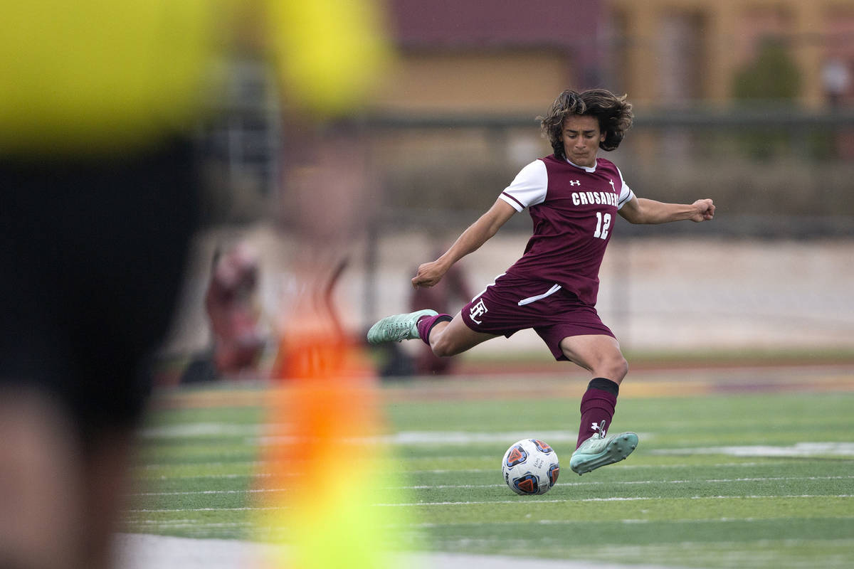 Faith Lutheran defender Logan Renteria (12) winds up to pass during a high school soccer game a ...