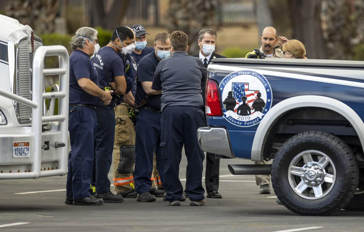 Emergency personnel look at a photo of a suspicious item on the ground at the Nevada Veterans M ...