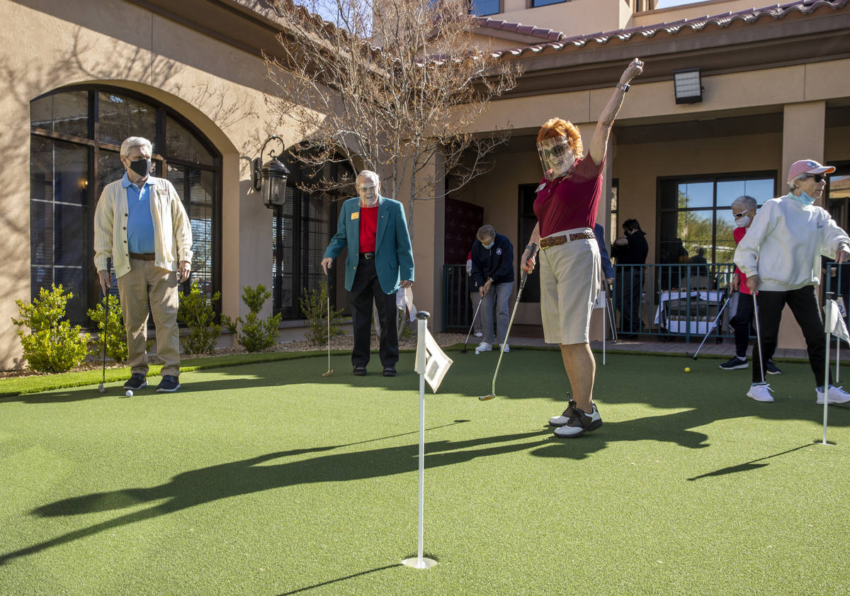Kay Harmon, center, celebrates a putt on the community's newly installed putting green at Las V ...