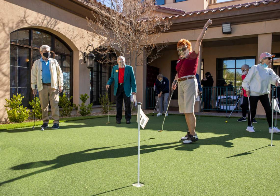 Kay Harmon, center, celebrates a putt on the community's newly installed putting green at Las V ...
