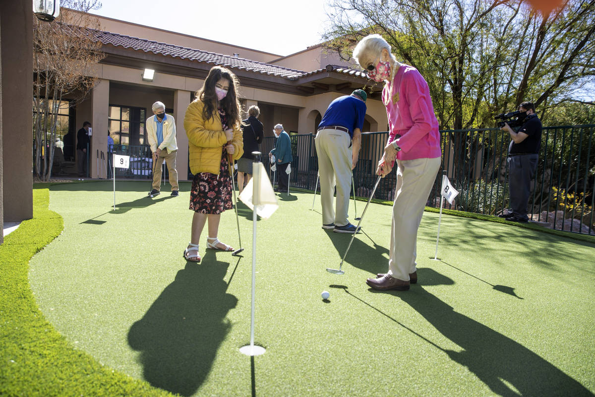 Hailey Cuthbert, 9, left, watches as her great-grandmother Ellie Levi, 90, putts a ball at Las ...