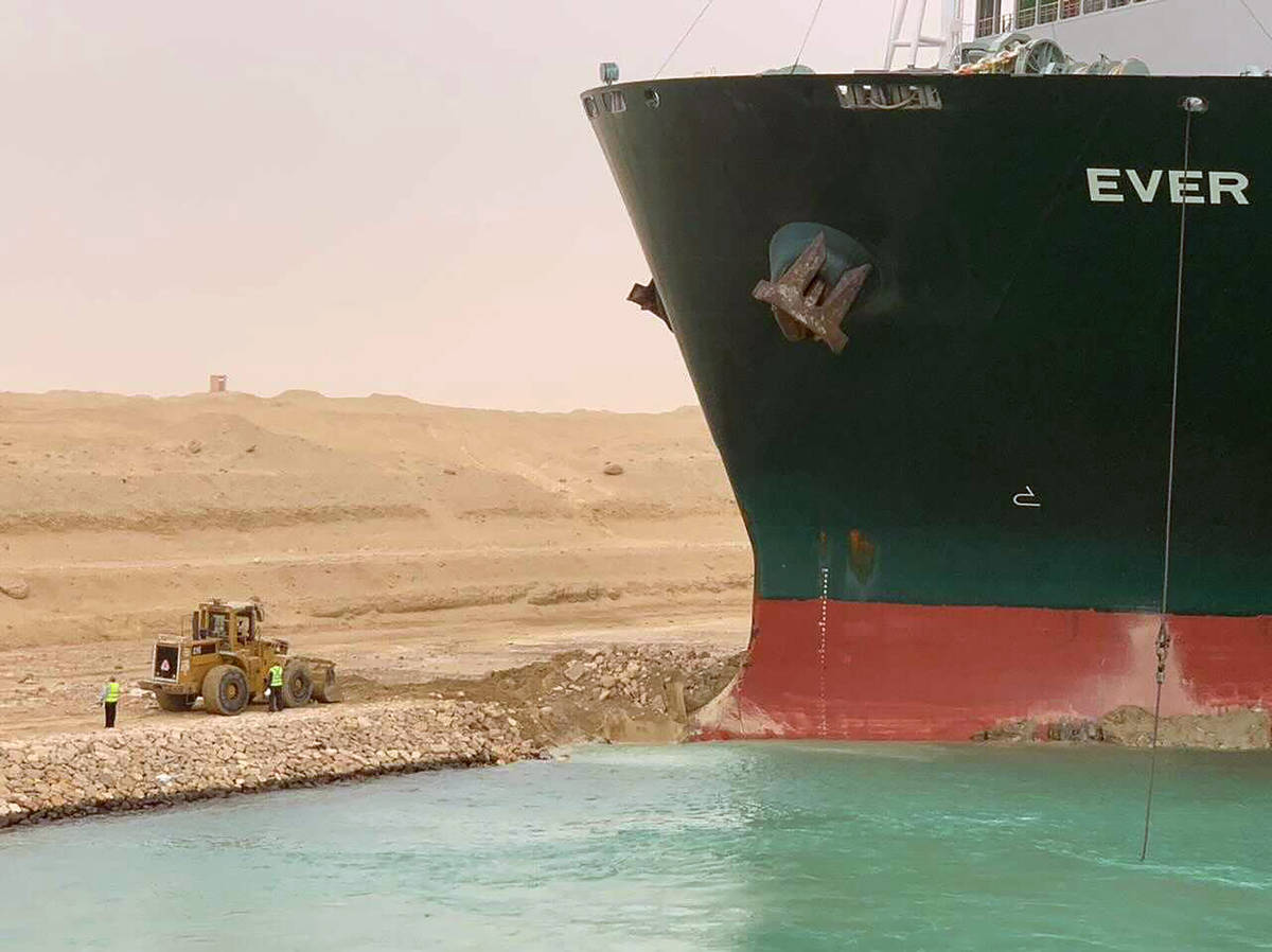 In this photo released by the Suez Canal Authority, a cargo ship, named the Ever Green, sits wi ...