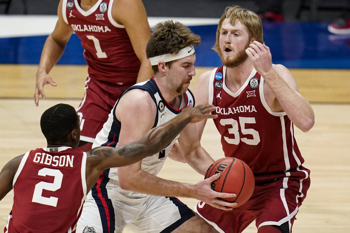 Gonzaga forward Drew Timme (2) drives between Oklahoma guard Umoja Gibson (2) and forward Brady ...