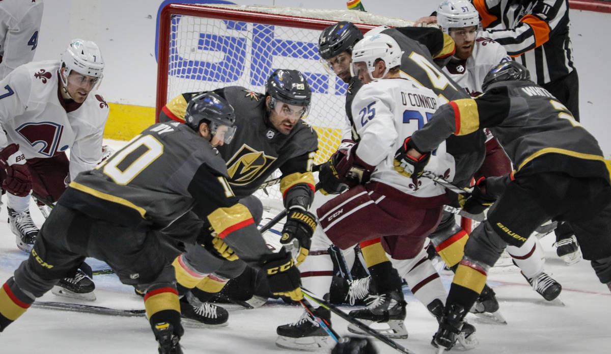 Vegas Golden Knights left wing William Carrier (28) and center Nicolas Roy (10) reach for the ...