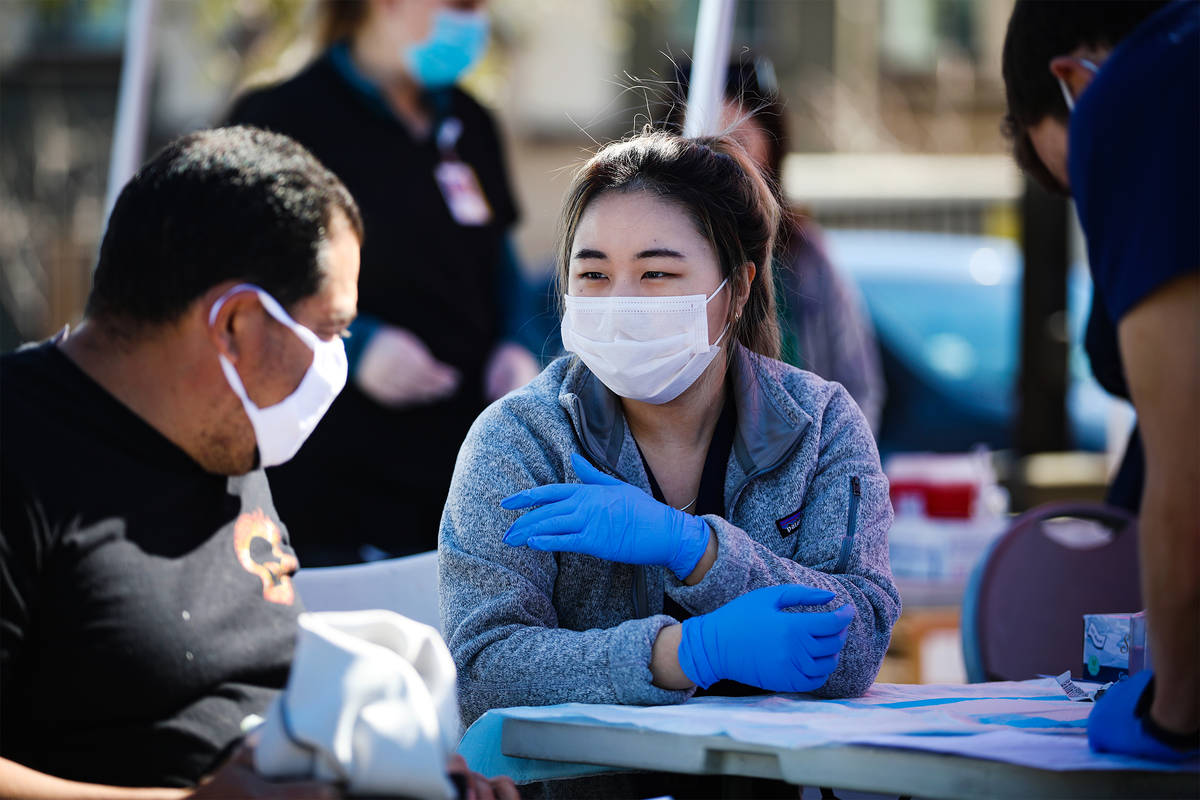 Debbie Min, right, a physician assistant student from Touro University, talks to Hugo Fernandez ...