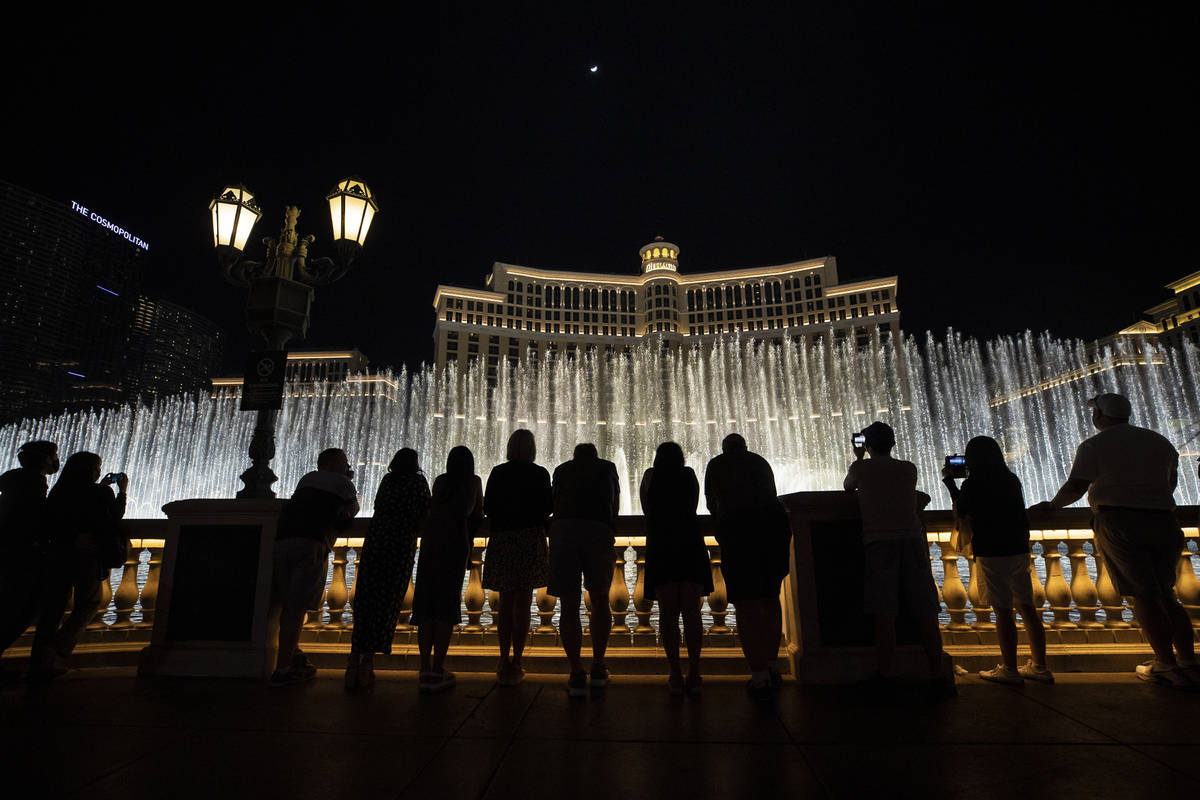 Visitors enjoy the Fountains of Bellagio show on Friday, March 19, 2021, in Las Vegas. (Benjami ...