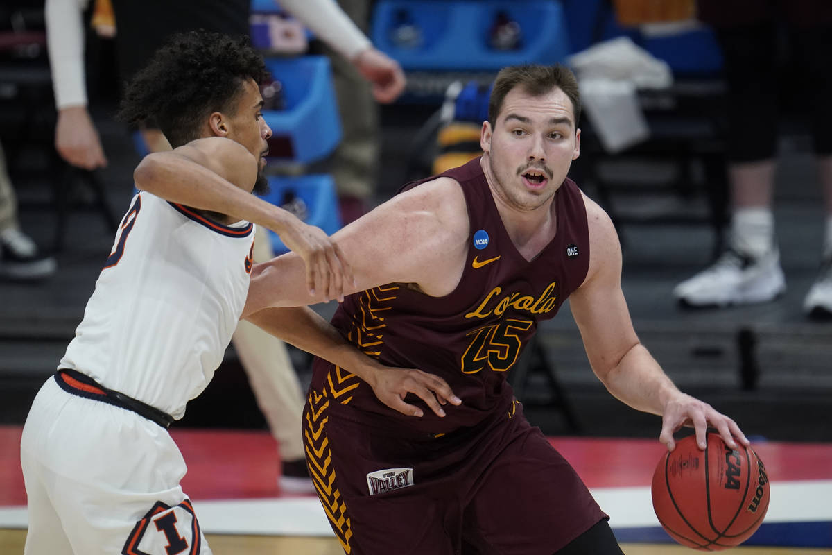 Loyola Chicago center Cameron Krutwig (25) drives on Illinois guard Jacob Grandison (3) during ...