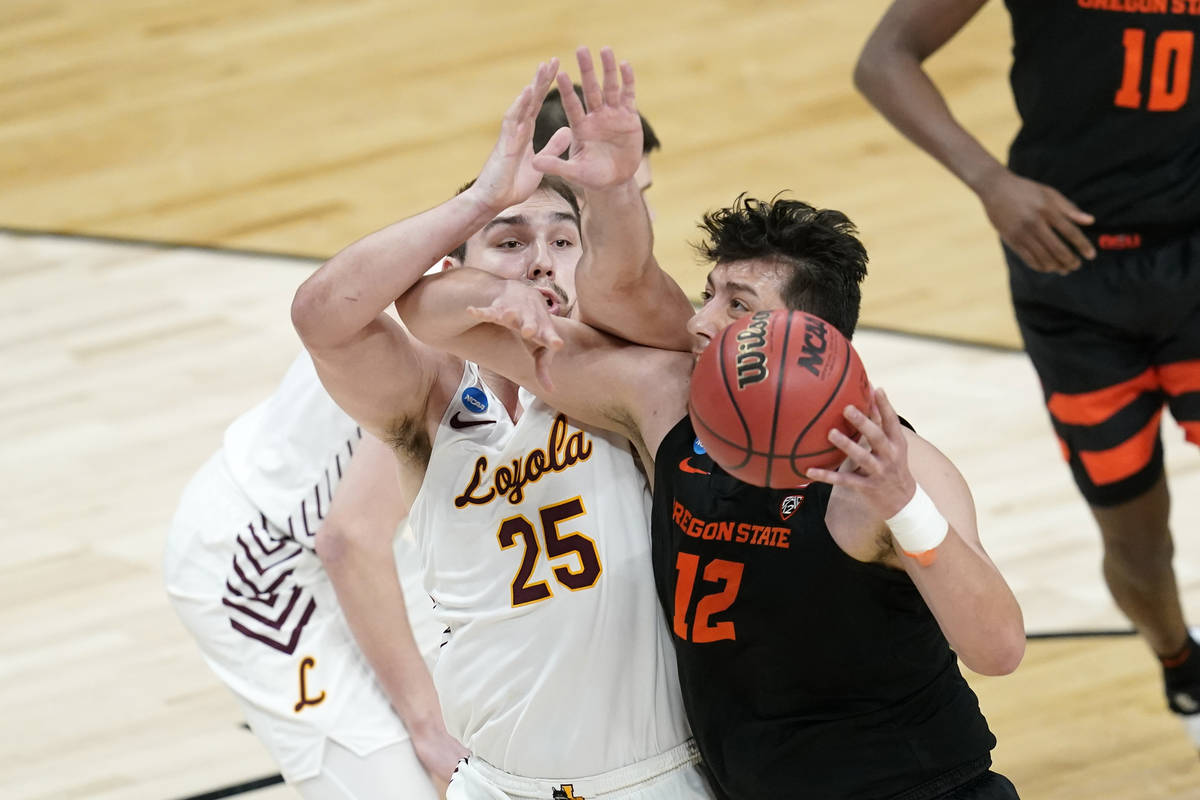 Oregon State center Roman Silva (12) drives past Loyola Chicago center Cameron Krutwig (25) dur ...