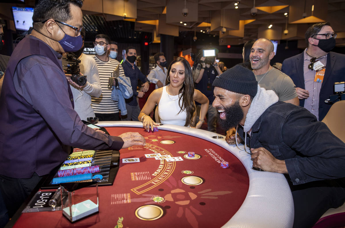 Matt James, right, with Melissa George, center, reacts to the final card being laid down as he ...