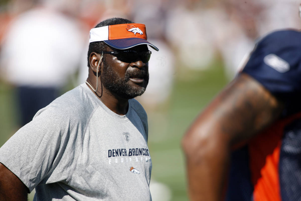 Denver Broncos defensive lines coach Wayne Nunnely looks on as players take part in drills duri ...
